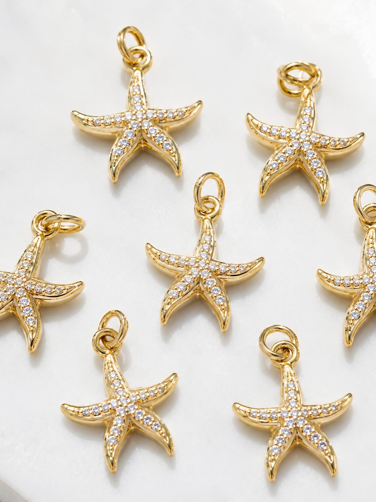 14k gold-plated seastar charm pendants with sparkling cubic zirconia accents on a delicate gold chain.
