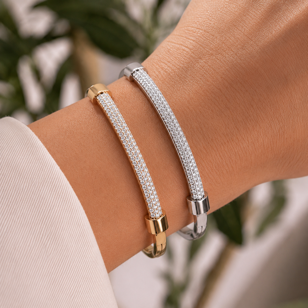 Gold and silver crystal pavé bangle bracelets stacked on a woman’s wrist.