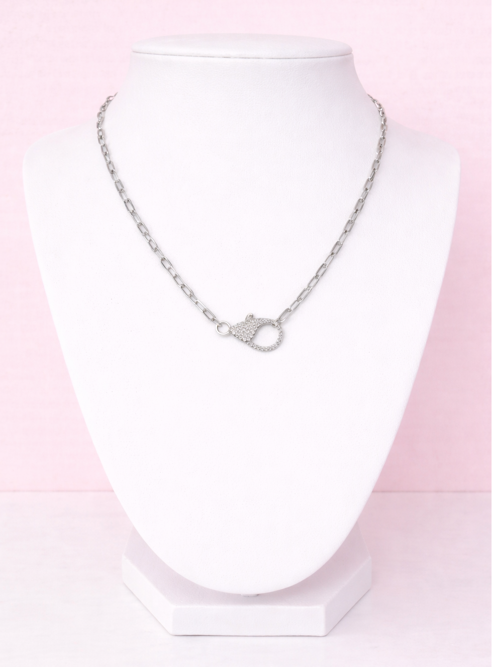 Silver necklace on a mannequin with a pink gradient background