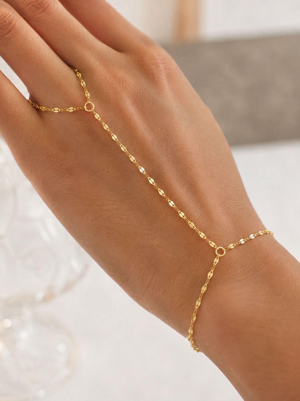 Close-up of the Fingerling Bracelet featuring a delicate 14k gold plated hand chain with adjustable bracelet and finger ring.