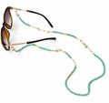 Sunglasses with a turquoise beaded chain on a white background