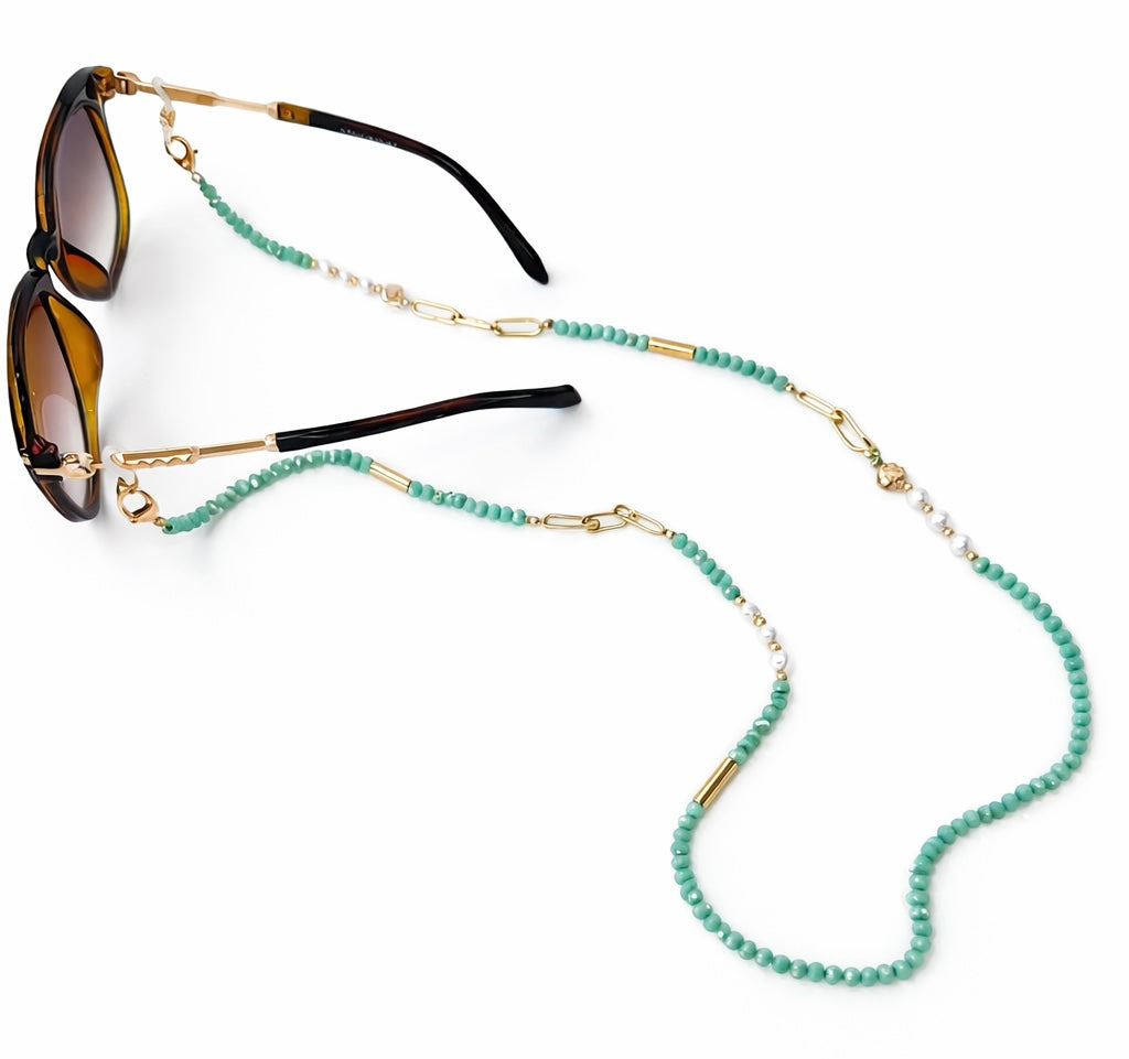 Sunglasses with a turquoise beaded chain on a white background