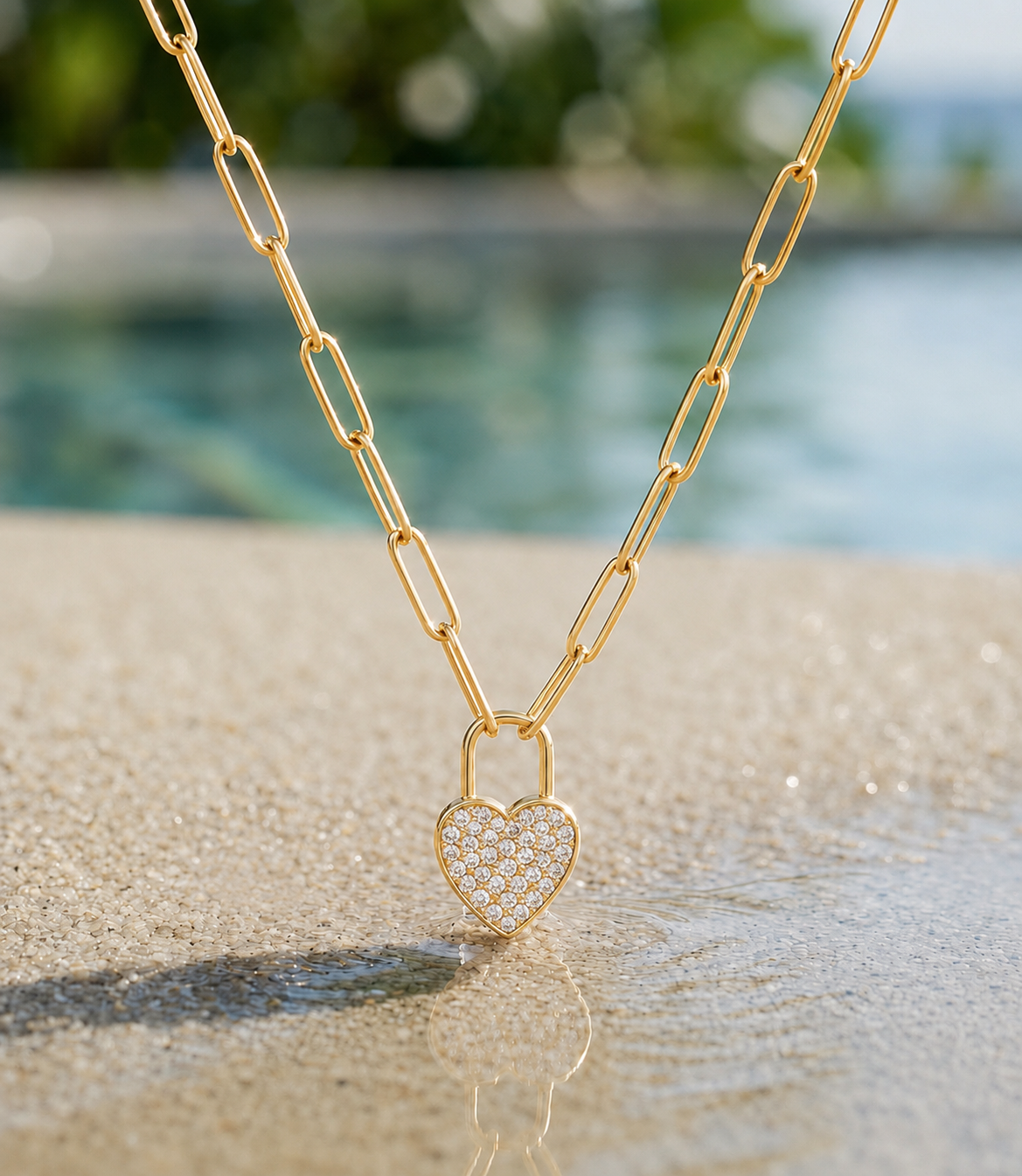 18k gold plated stainless steel paperclip chain with Pavé heart pendant on beach background 