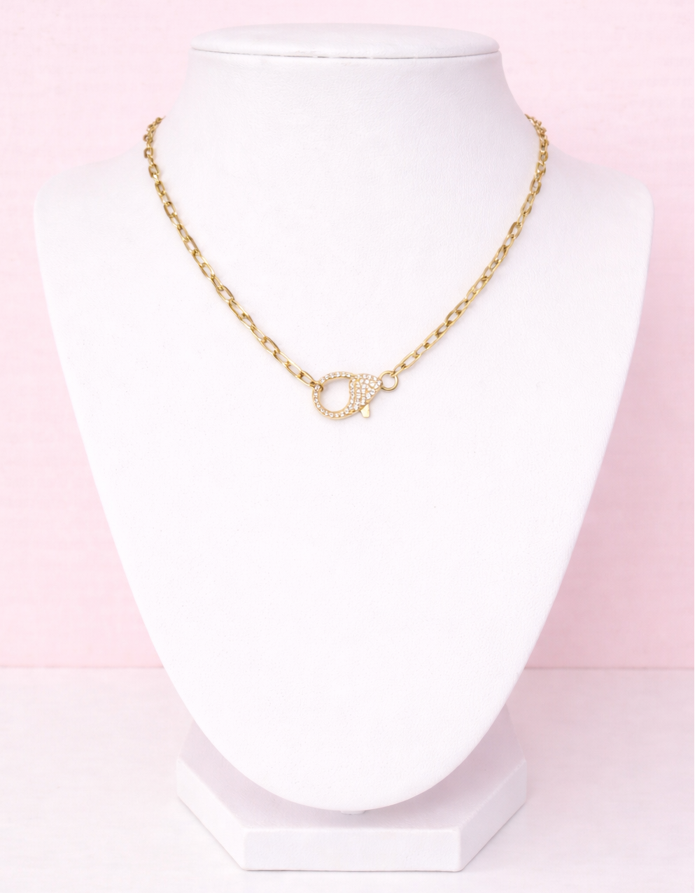 Gold necklace on a mannequin with a pink gradient background