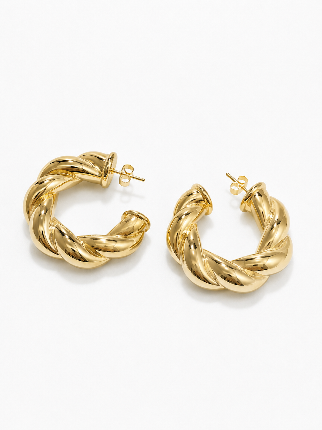 Gold twisted hoop earrings with a chunky rope-inspired design on a white background.
