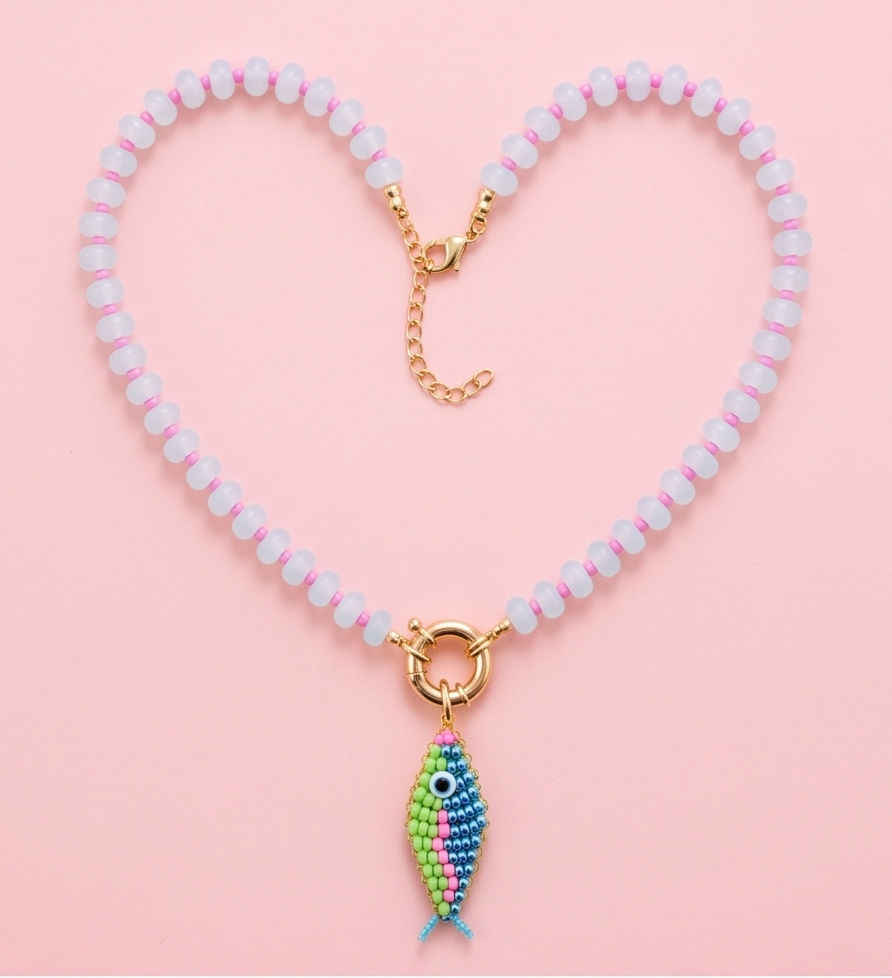 Lucky Catch fish charm necklace arranged in a heart shape on a soft pink background.