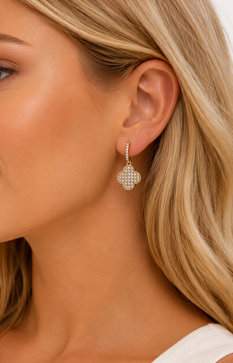 Model wearing Lucky Clover Earrings featuring a 14k gold-plated clover drop design with pavé cubic zirconia crystals.