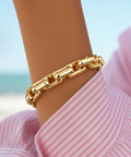 Cooper Bracelet in 14 karat gold plating worn on wrist, featuring polished rectangular links and a bold everyday statement look.