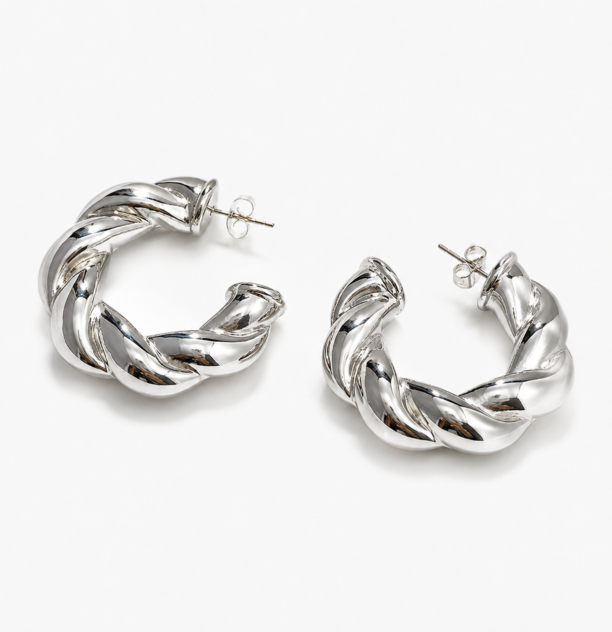 Silver twisted hoop earrings with a chunky rope-inspired design on a white background.