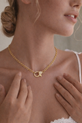 Gold necklace with a unique clasp worn by a person
