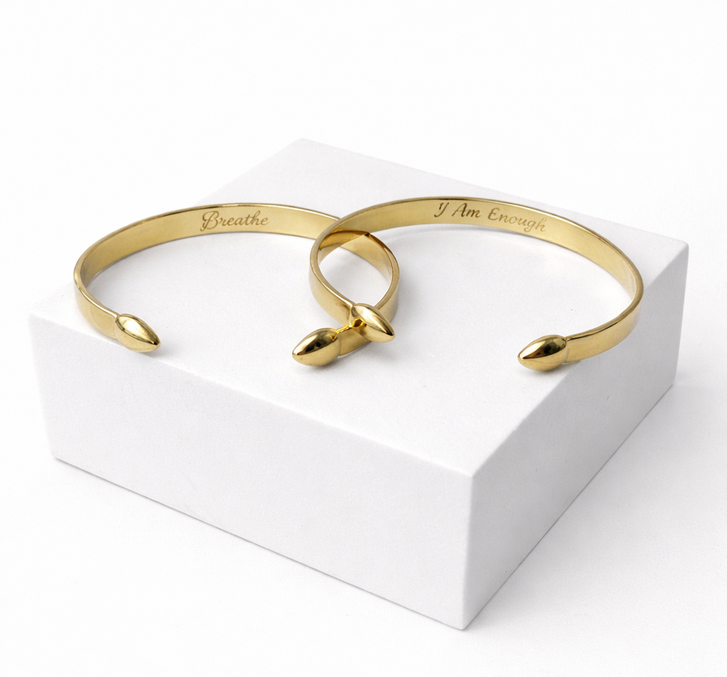 Gold bracelets on a white stand with a white background