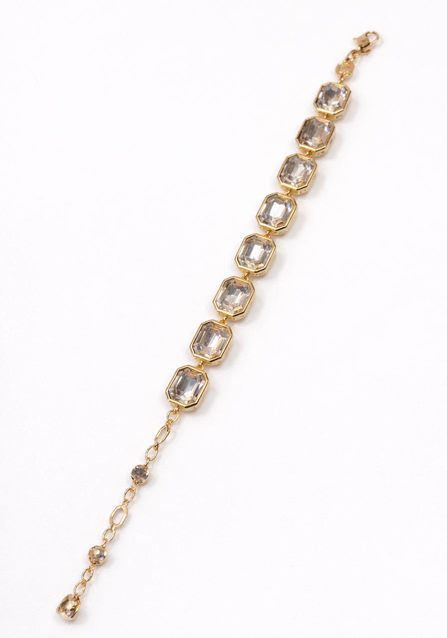 Gold bracelet with emerald cut golden gemstones on a white background