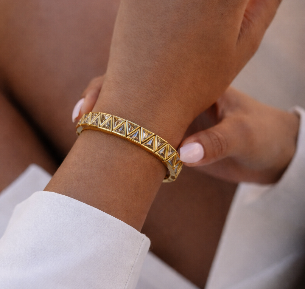 Gold bracelet on a wrist with a blurred background
