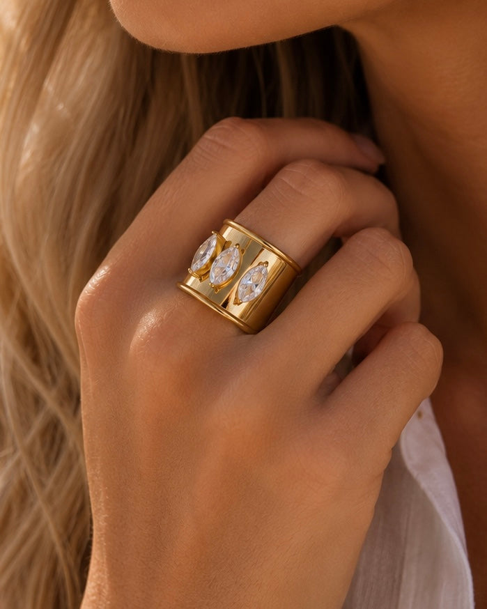 Woman wearing the Bali Ring, an adjustable 18k gold-plated stainless steel statement ring with three marquise-cut cubic zirconia stones.