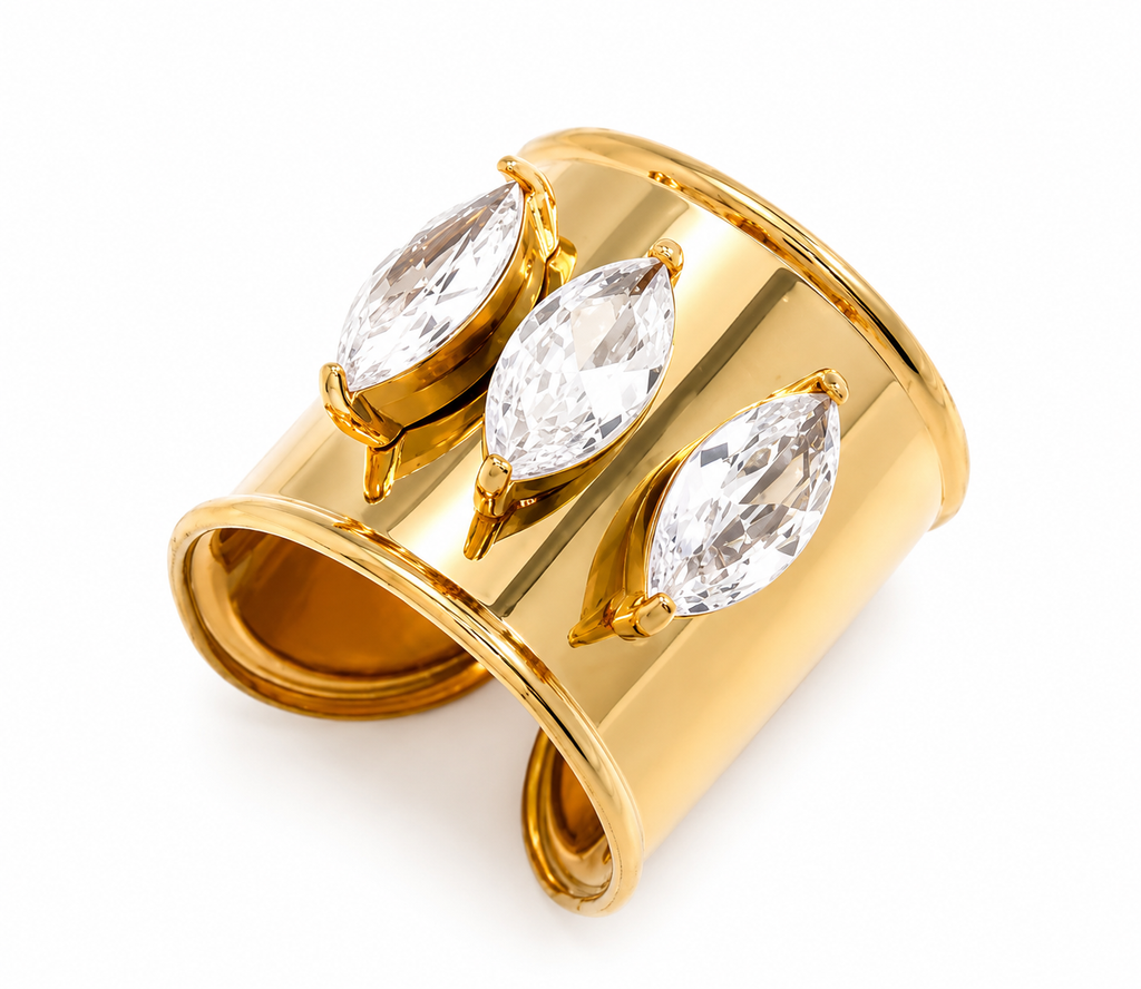 Bali Ring featuring three marquise-cut cubic zirconia stones in an adjustable 18k gold-plated stainless steel band on a sandy beach.