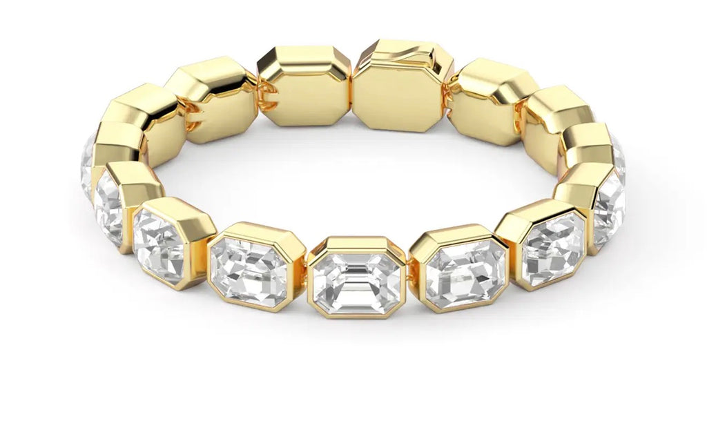Close-up of gold bracelet with clear rectangular crystals catching light