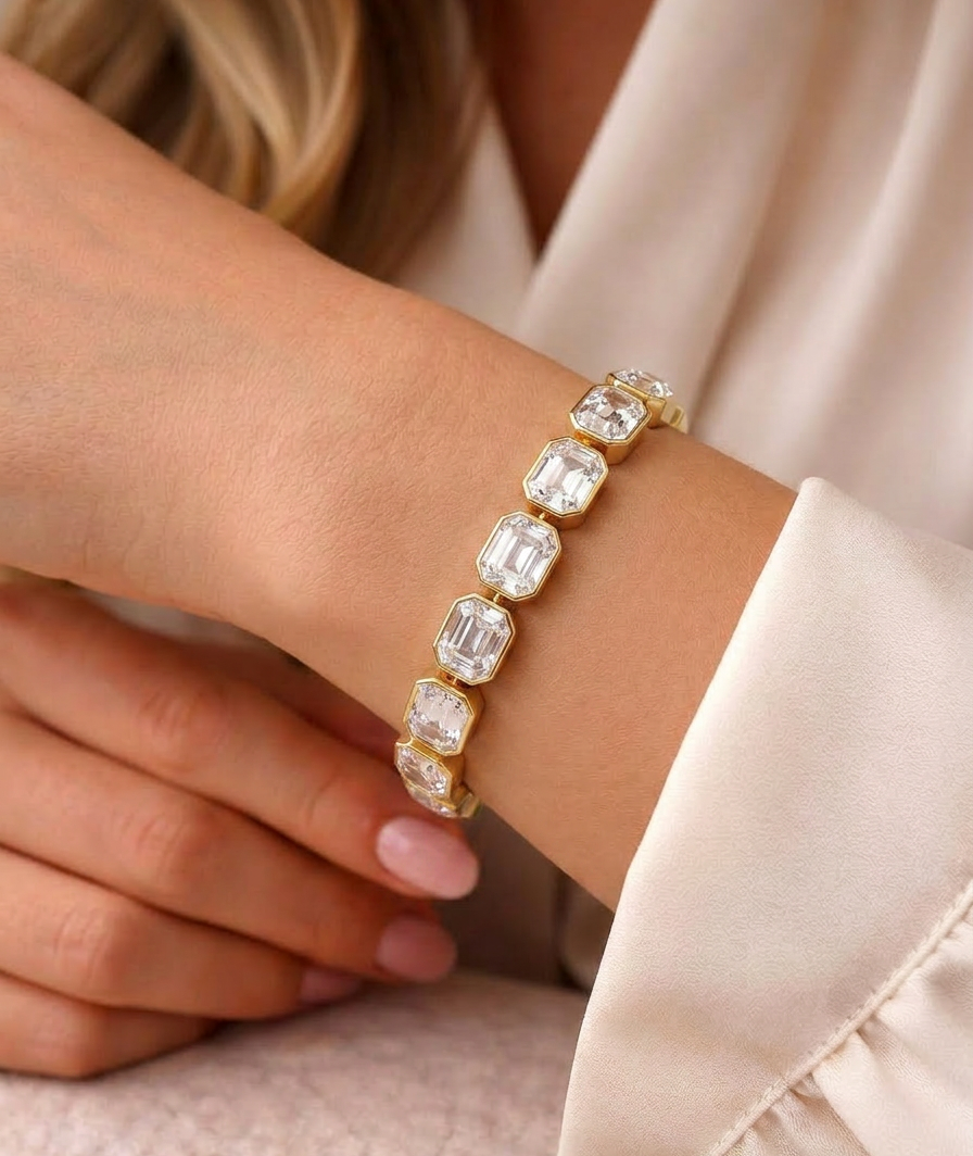 Close-up of gold bracelet with clear rectangular crystals catching light