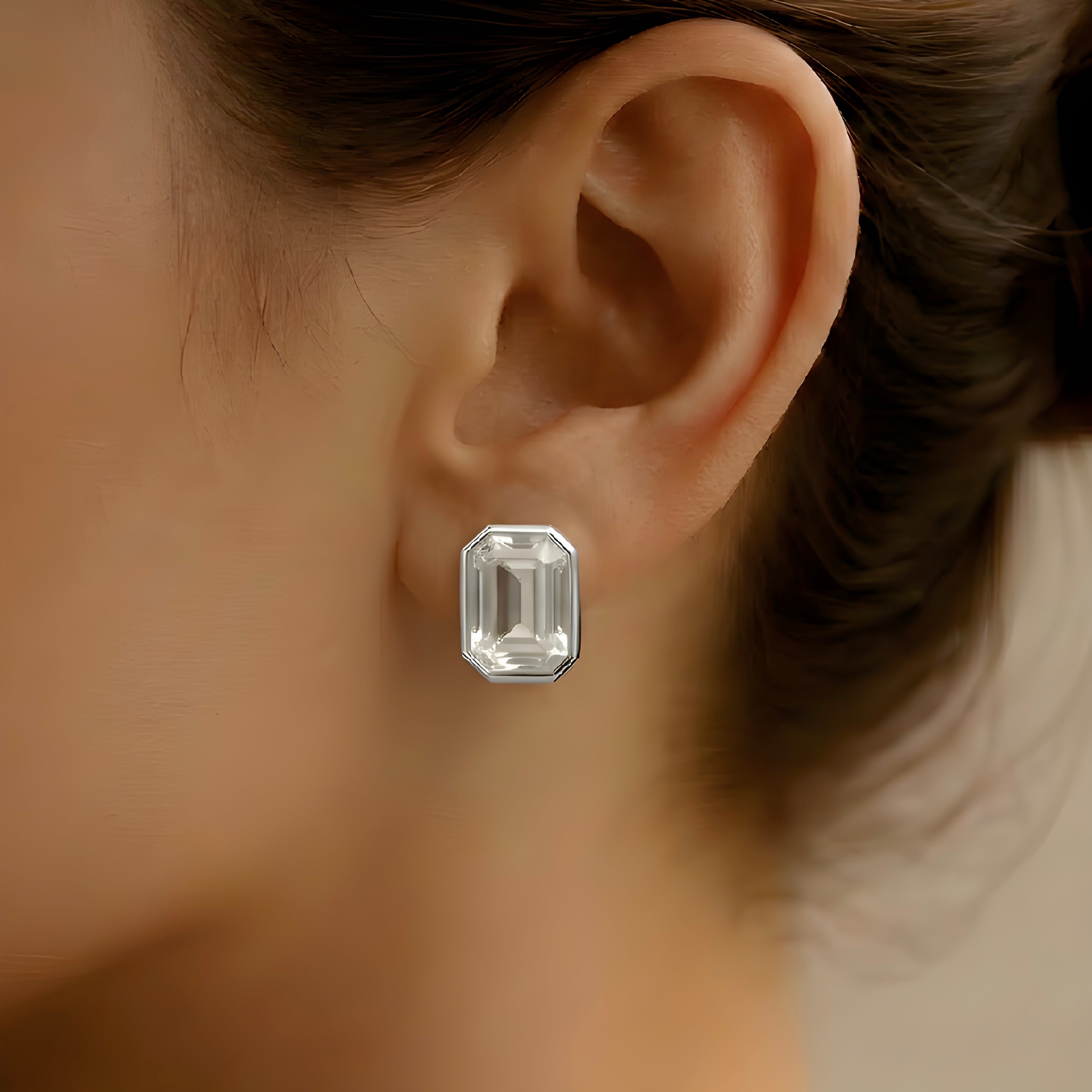 Close-up of an emerald-cut diamond earring on a blurred background