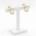 Gold octagon crystal stud earrings on white display stand