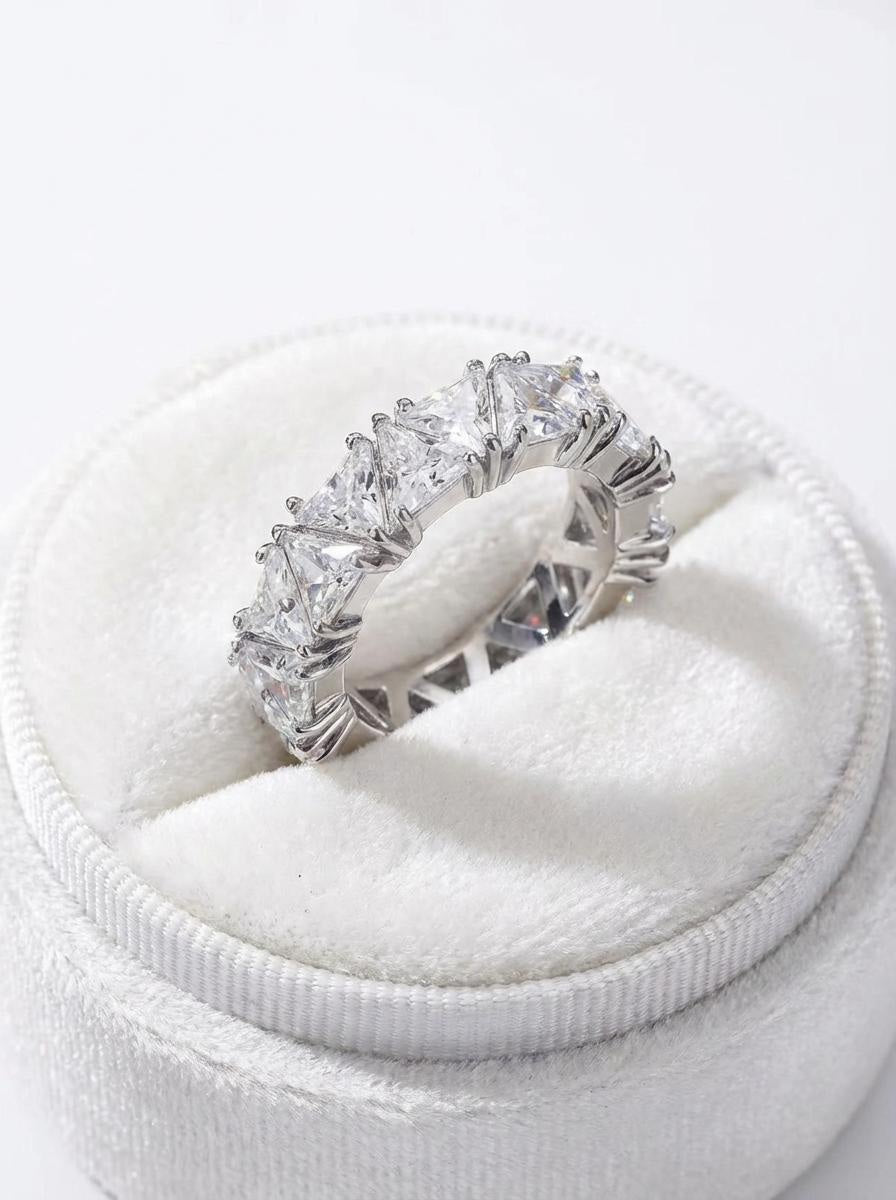 Silver statement ring with faceted clear stones resting in a white ring box