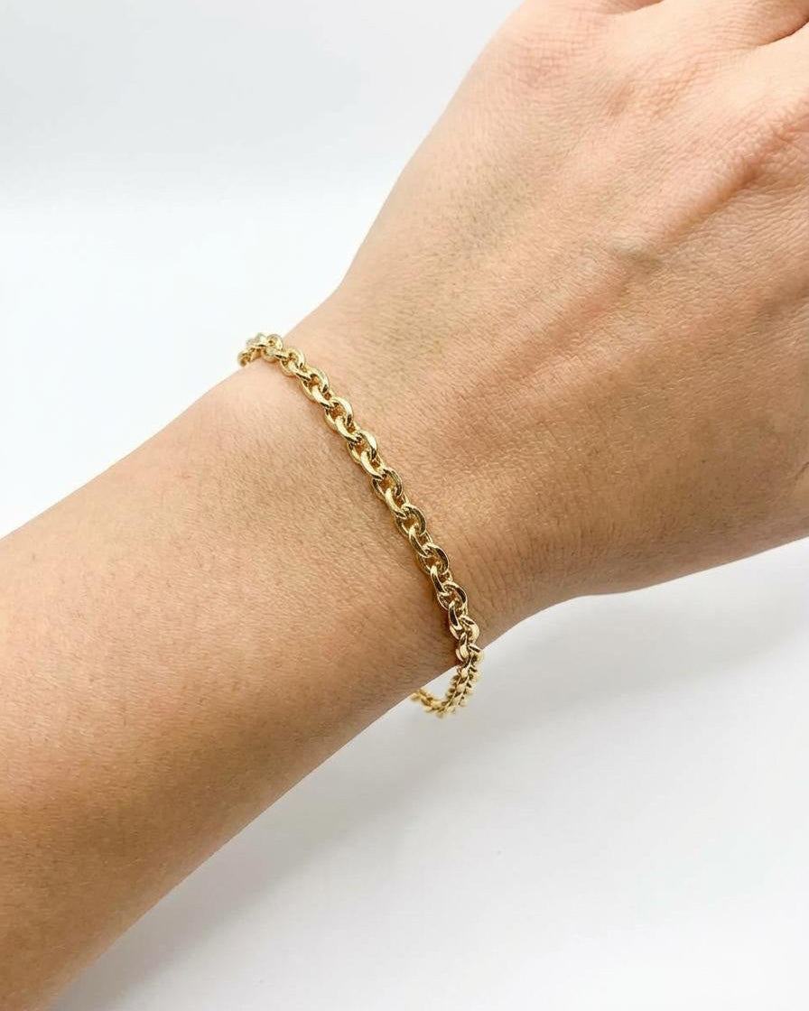 Gold, oval cable chain bracelet, worn on wrist