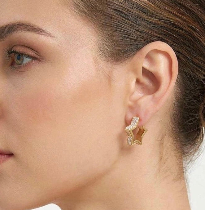 Gold star earring, worn on ear close view