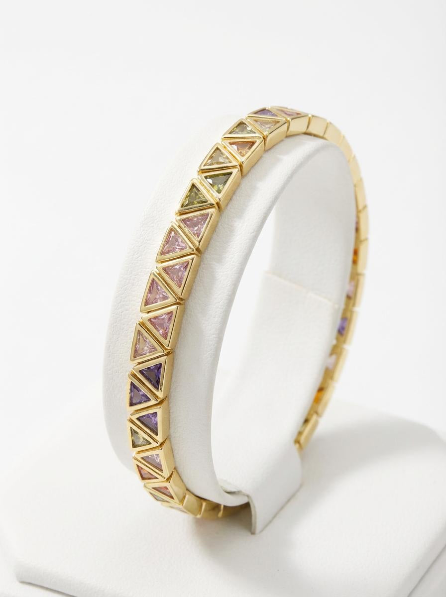 Gold stretch bracelet with multicolour triangular cubic zirconia stones, photographed on white background