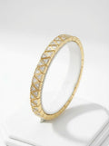 Gold stretch bracelet with clear triangular cubic zirconia stones, photographed on white background