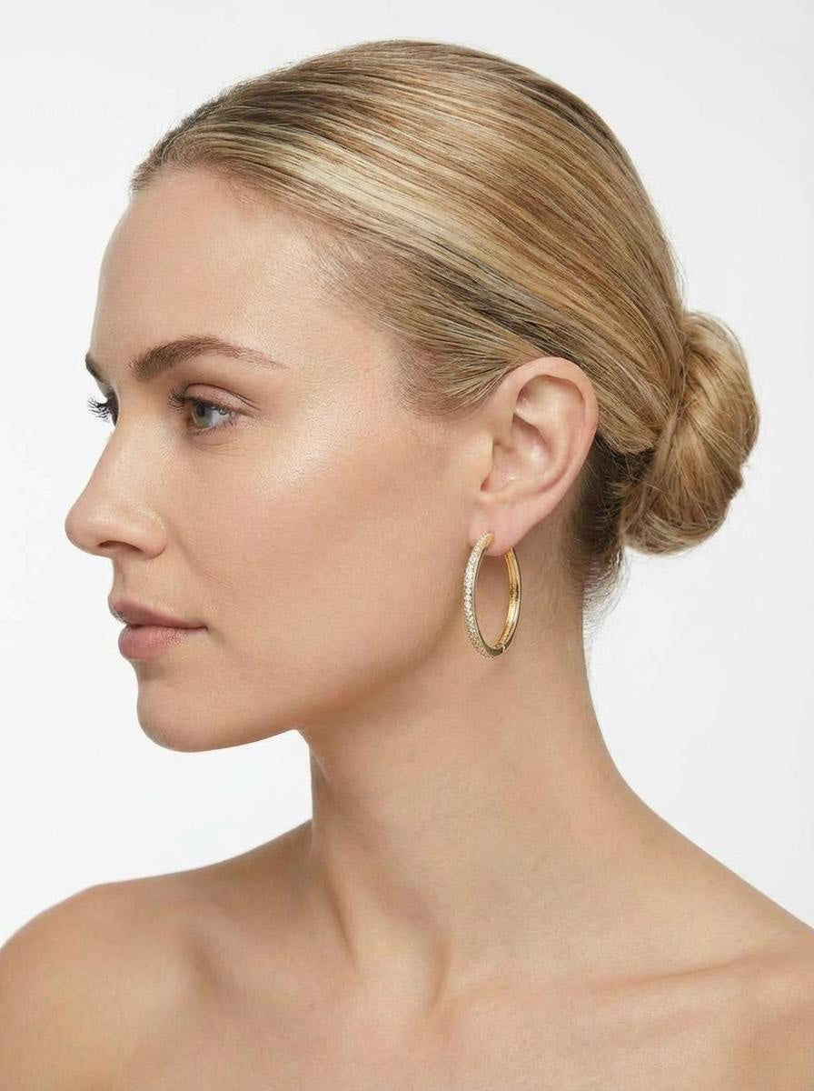 Model wearing medium-sized gold hoop earrings with subtle sparkle