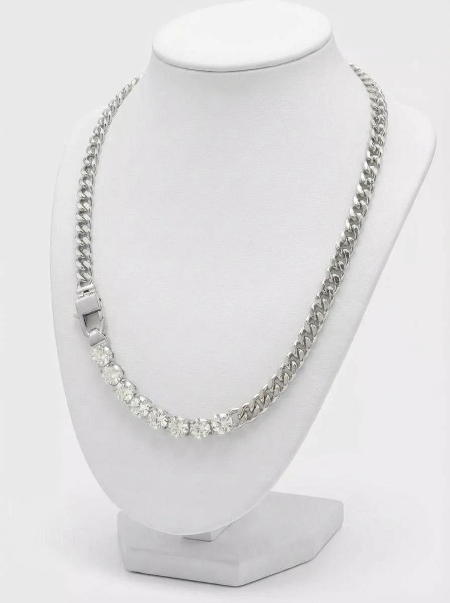 Silver toned curb link necklace with row of clear cubic zirconia stones on display bust