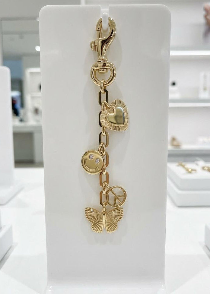 Rhodium tone, charms displayed on a jewelry, stand with heart, smile face, peace symbol, and butterfly accent