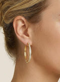 Gold hoop earring showed on model for a neutral display