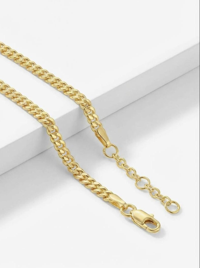 Close up of gold tone curb chain bracelet with adjustable extension