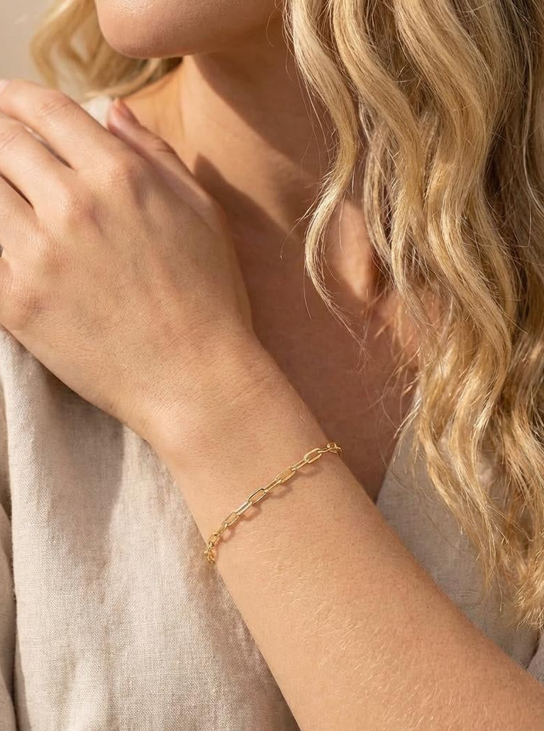 Model wearing a 14K gold plated paper clip chain bracelet on wrist