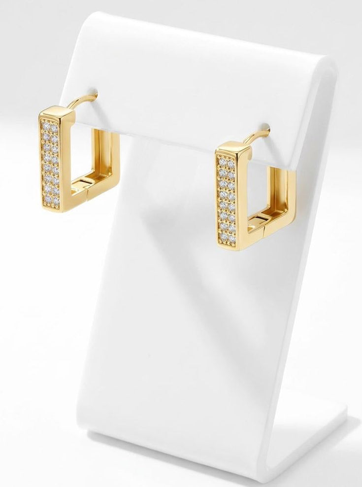 Close-up of gold square huggie hoop earrings with embedded cubic zirconia