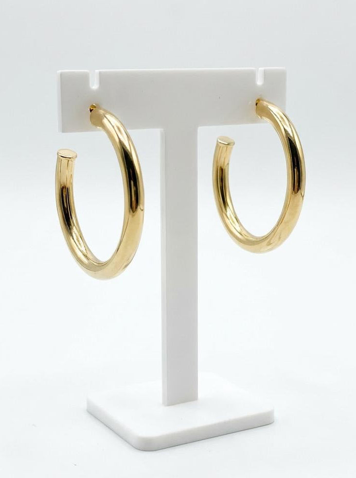 14K gold plated hoop earrings with smooth rounded silhouette on display stand