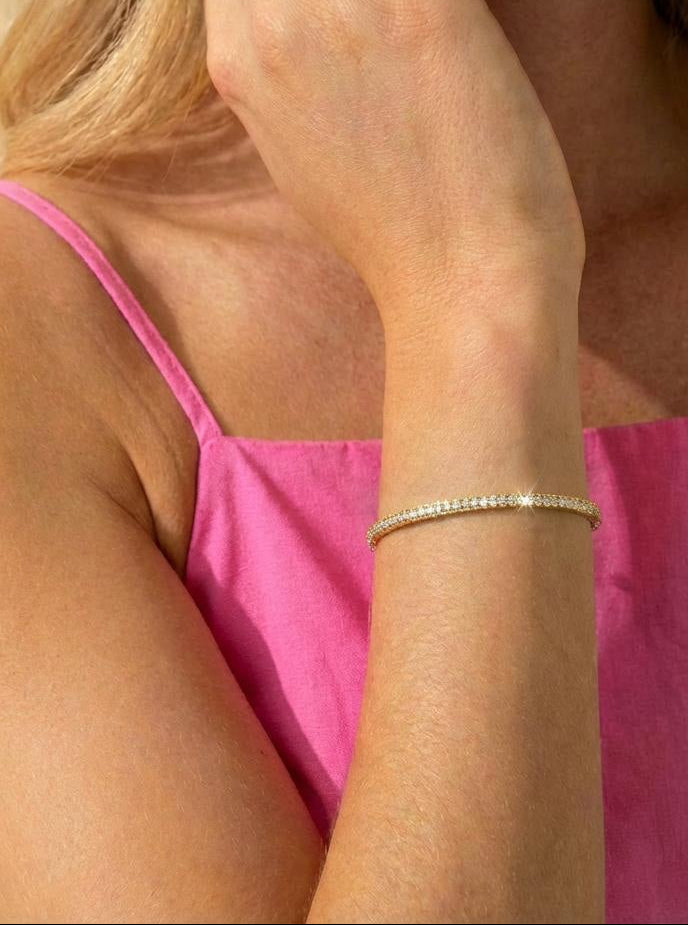Woman wearing a gold bangle tennis bracelet