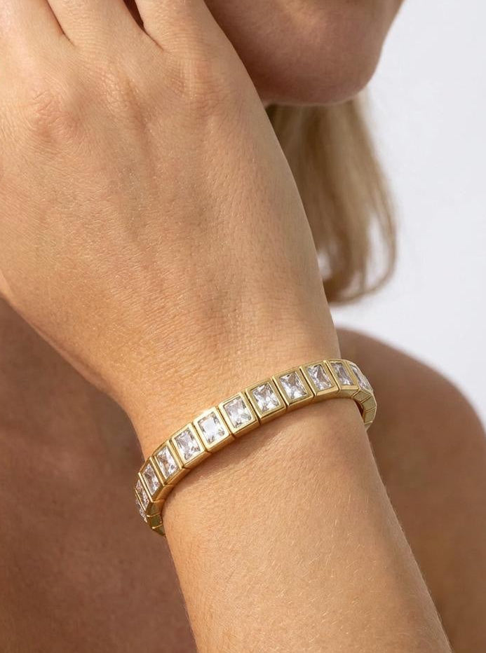 Model wearing a gold-plated enamel tile bracelet with clear crystal accents