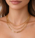 Gold layered chain necklace on a person's neck