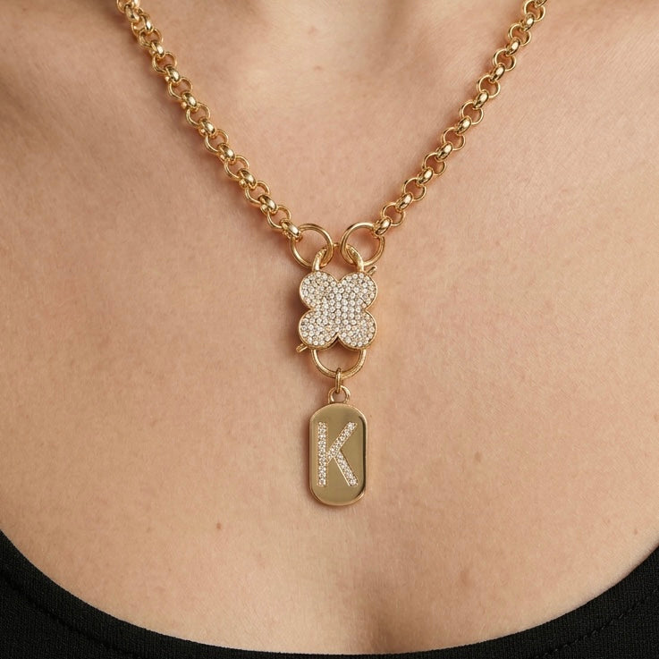 Gold clover charm necklace with cubic zirconia stones on stainless steel chain worn by model, Haus of Sugar boutique jewelry