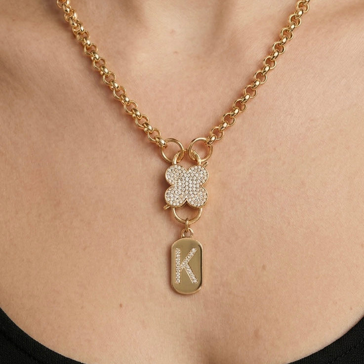 Gold initial charm pendant necklace with cubic zirconia letter on delicate gold chain worn by model