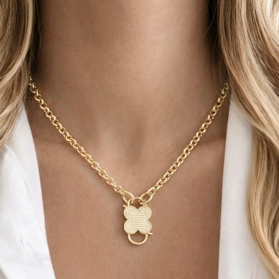 Gold clover charm necklace with cubic zirconia stones on stainless steel chain worn by model, Haus of Sugar boutique jewelry