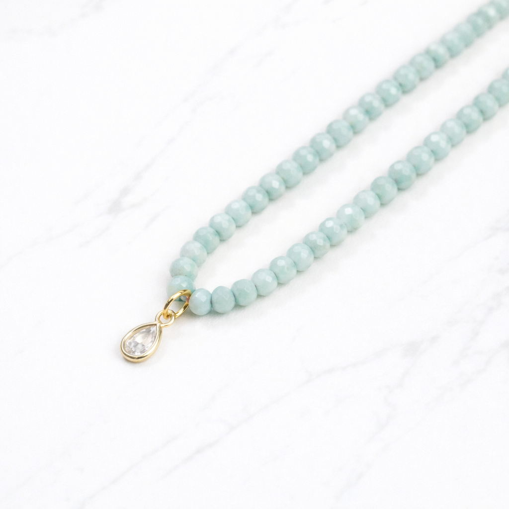 Iridescent mint green glass bead necklace with gold teardrop crystal pendant on delicate chain