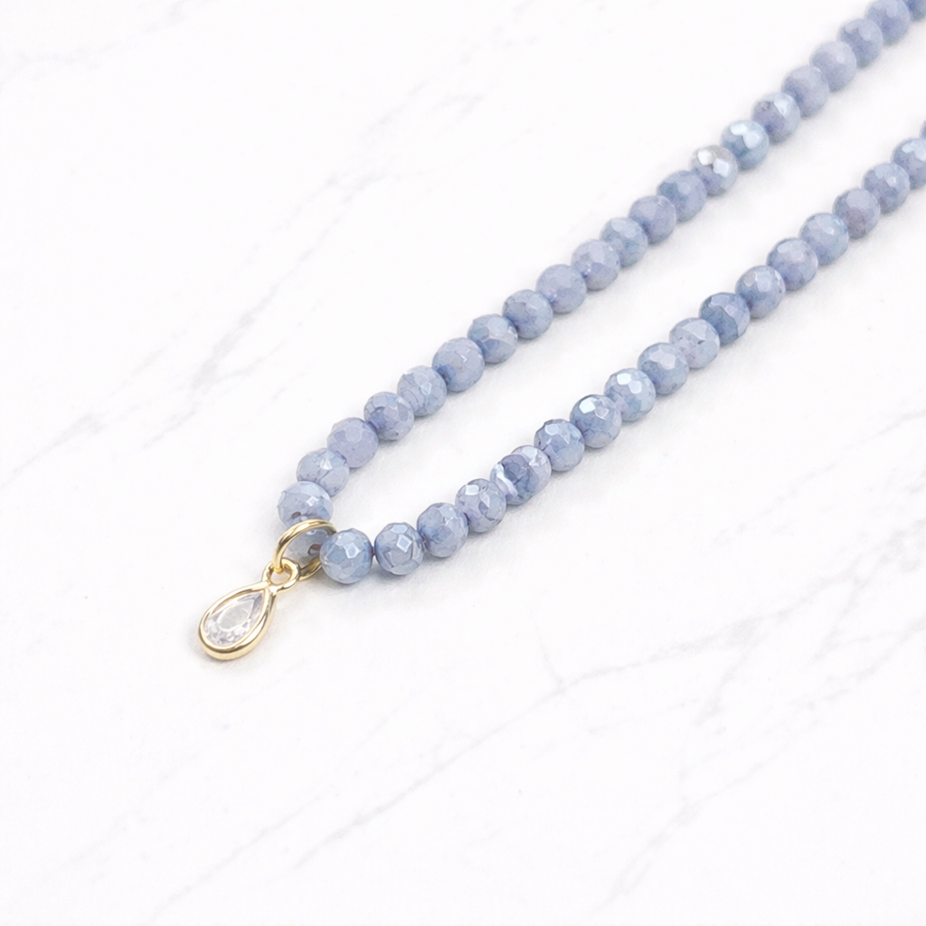 Iridescent icy blue grey glass bead necklace with gold teardrop crystal pendant on delicate chain