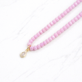 Iridescent pink glass bead necklace with gold teardrop crystal pendant on delicate chain