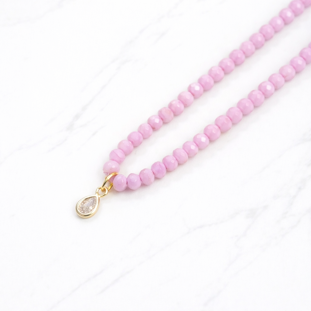 Iridescent pink glass bead necklace with gold teardrop crystal pendant on delicate chain