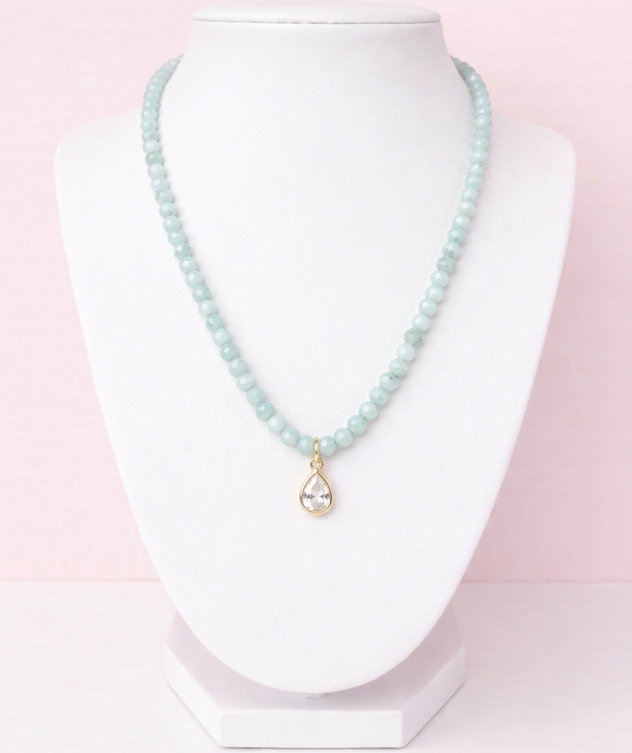 Iridescent mint green glass bead necklace with gold teardrop crystal pendant on delicate chain