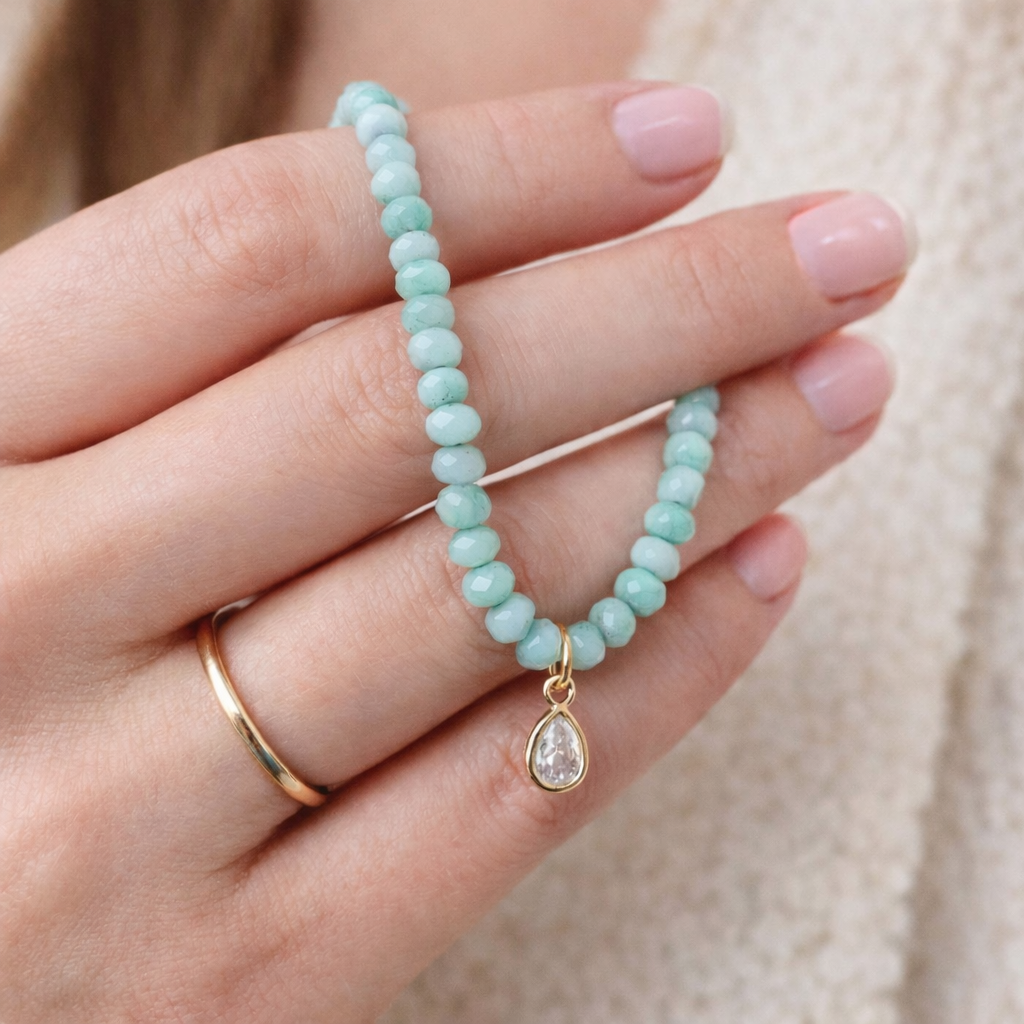Iridescent mint green glass bead necklace with gold teardrop crystal pendant on delicate chain