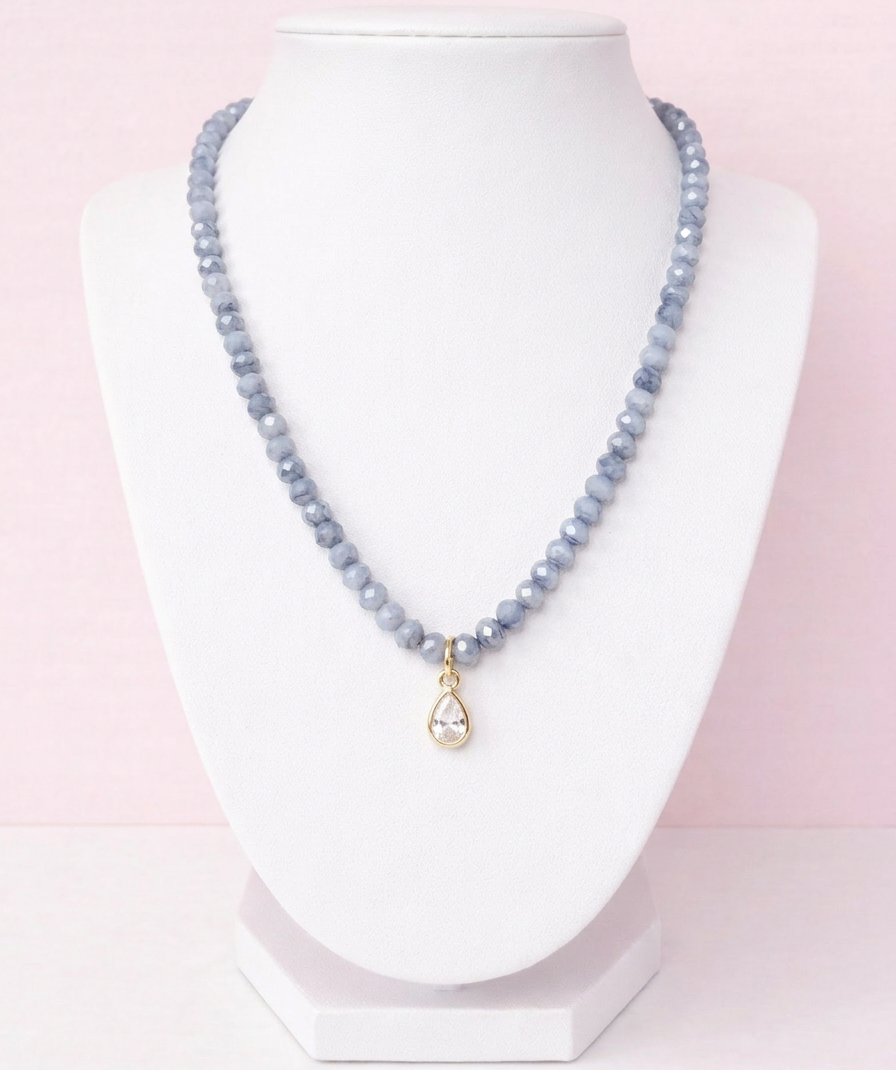 Iridescent icy blue grey glass bead necklace with gold teardrop crystal pendant on delicate chain