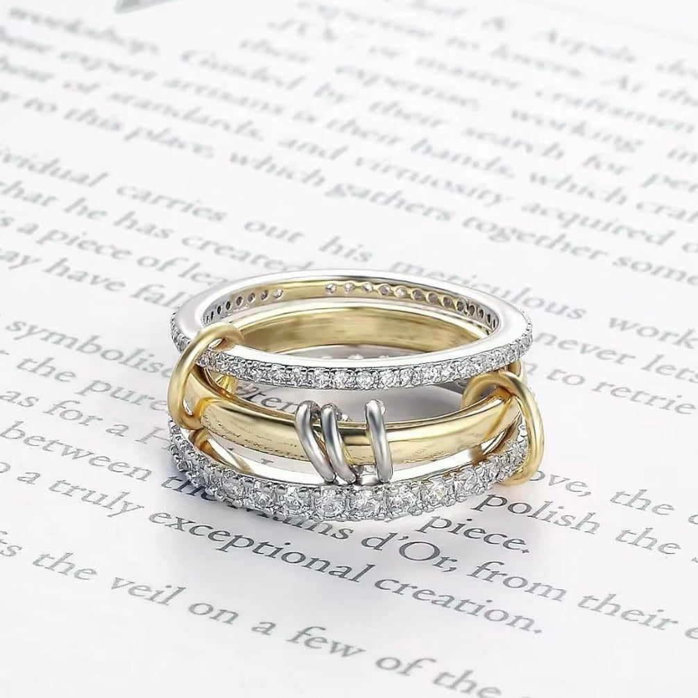 Three gold and silver rings stacked on top of each other with text in the background